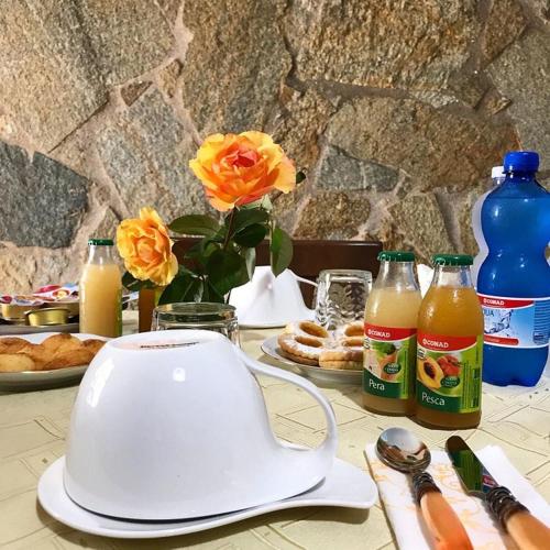 a table with a toaster and flowers and bottles of juice at BREAKFAST SA BETTUA in Càbras