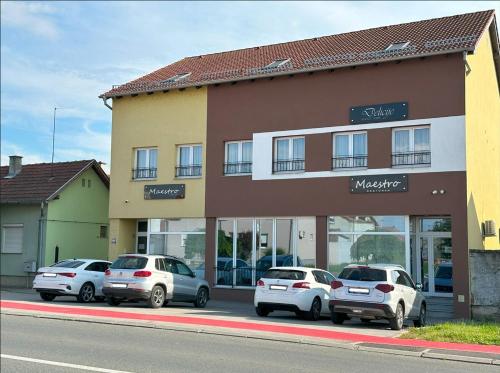 a group of cars parked in front of a building at Maestro - Rooms & Restaurant in Vukovar