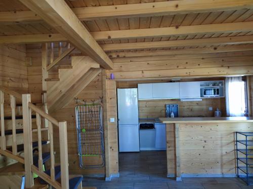 a kitchen in a log cabin with a staircase at 4 Domki u Ewy in Ryn