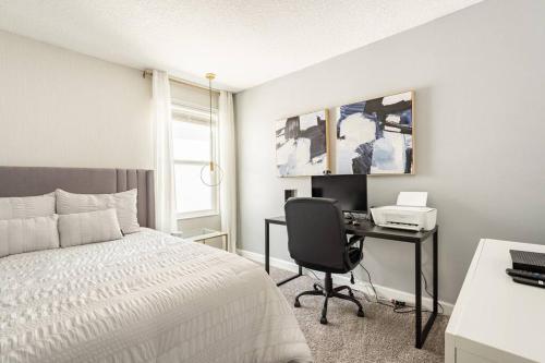 ein Schlafzimmer mit einem Bett und einem Schreibtisch mit einem Computer in der Unterkunft Elegant Luxury Villa Movie Room Private Pool in Kissimmee