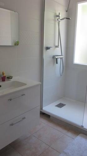 une salle de bain blanche avec une douche et un lavabo dans l'établissement Maison de ville lumineuse avec jardin, à Gardanne