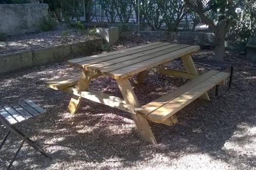 ガルダンヌにあるMaison de ville lumineuse avec jardinの公園内のピクニックテーブルとベンチ