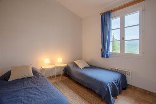 a bedroom with two beds and a window at Villa Domaine du golf de Roquebrune in Roquebrune-sur-Argens