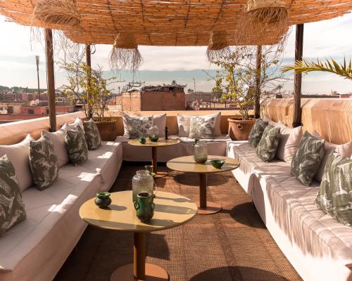a patio with couches and tables on a roof at 72 Hotel & Spa in Marrakech