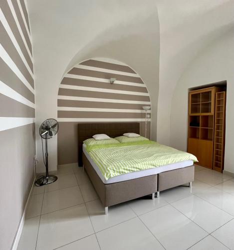 a bedroom with a bed with a striped ceiling at Palác Daun - Studio Apartments in Znojmo