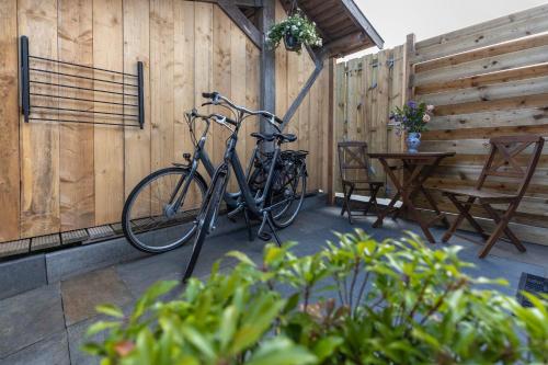 a bike is chained to a fence on a patio at Bed & Bike Schoudieck in Den Burg