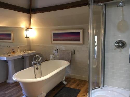 Kilburn的住宿－Highway Cottage，带浴缸、淋浴和盥洗盆的浴室