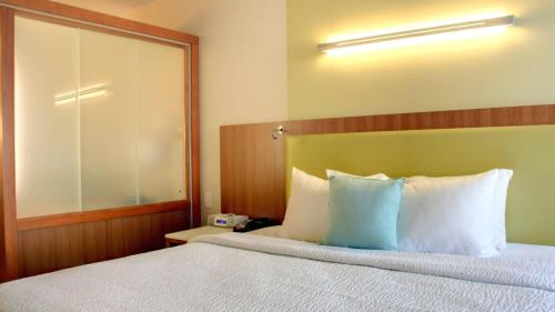 Habitación de hotel con cama con almohadas azules y blancas en SpringHill Suites by Marriott Scranton Montage Mountain, en Moosic