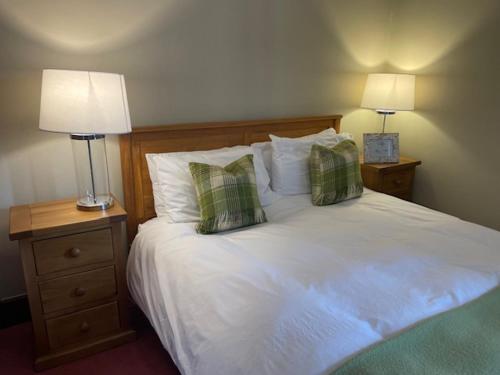 a bedroom with a white bed with pillows and two lamps at Brooklynn Guest House in Grantown on Spey