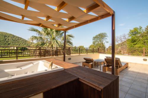 a large deck with a bath tub and a balcony at Riviera Perdika Hotel in Perdika