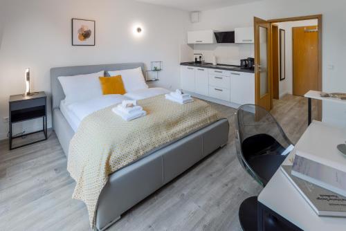 een slaapkamer met een bed en een keuken bij MINT: Design Studio – Parken – Küche – WiFi in Dortmund