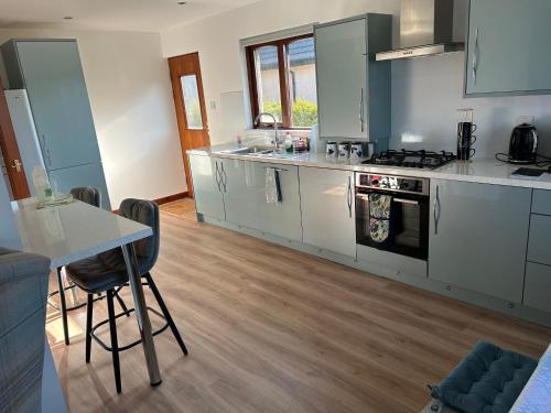 a kitchen with stainless steel appliances and a table at Willow Lodge , Corskie Drive Macduff-Banff in Macduff