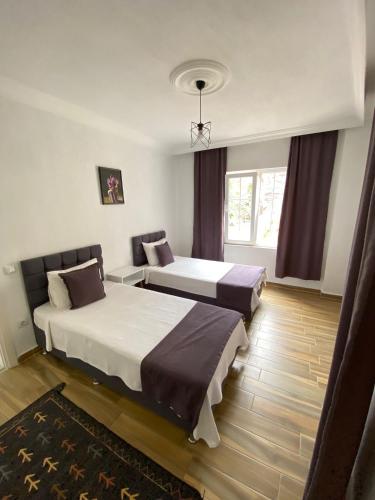 a hotel room with two beds and a window at KAŞ MERKEZ İMREN APART 1 in Kas