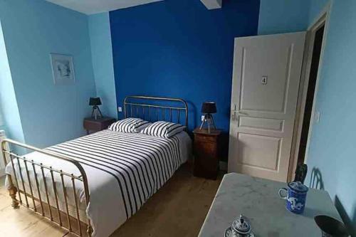 a bedroom with a bed and a blue wall at Maison de maître avec piscine in Lombers