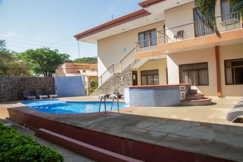 a swimming pool in front of a house at Nacazcol - Playas del Coco in Coco