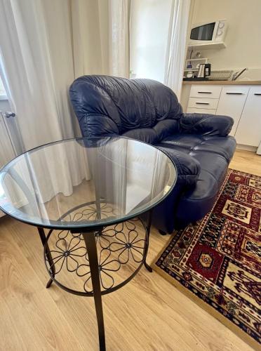 a glass table and a chair in a living room at Palác Daun - Studio Apartments in Znojmo