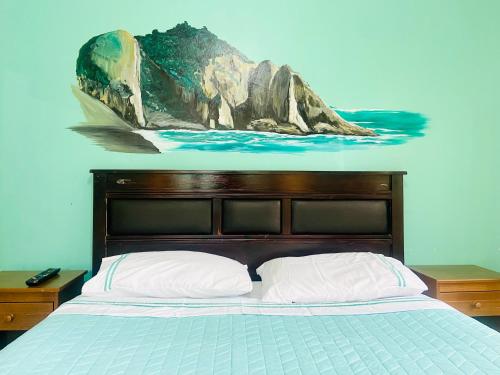 1 dormitorio con 1 cama con una pintura en la pared en Hostel Costa Morena, en Constitución