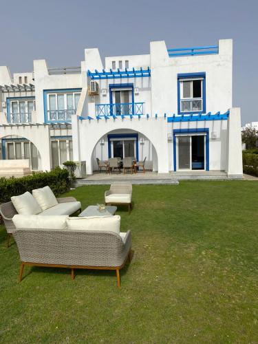 a large house with couches in the yard at 4 bedroom twin house in Mountain View Ras El Hekma near the North Coast in Sīdī ‘Abd ar Raḩmān