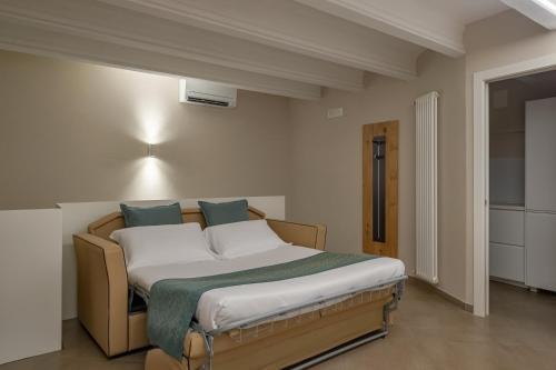 a bedroom with a bed with white sheets and blue pillows at Bonacolsi Collection, MantegnaHotels in Mantova