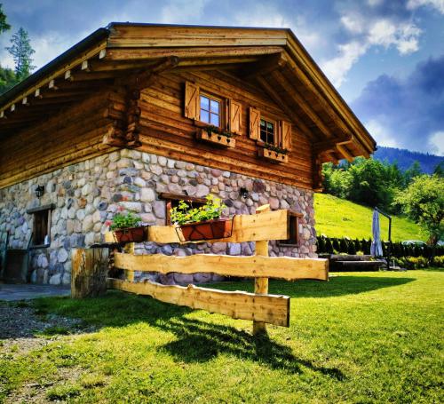 a log cabin with a fence in front of it at Baita dei Fovi in Baselga di Pinè