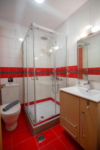 a bathroom with a shower and a toilet and a sink at Riviera Perdika Hotel in Perdika