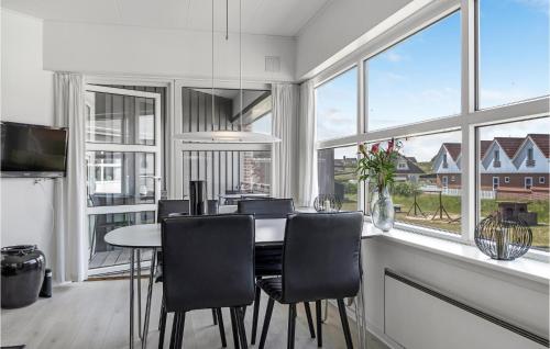 a dining room with a table and some windows at Fanø Bad, Lejl 107 in Fanø