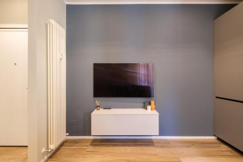Blue Suite by Studio Vita في بولونيا: غرفة معيشة مع تلفزيون على الحائط