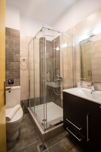 a bathroom with a shower and a toilet and a sink at Riviera Perdika Hotel in Perdika