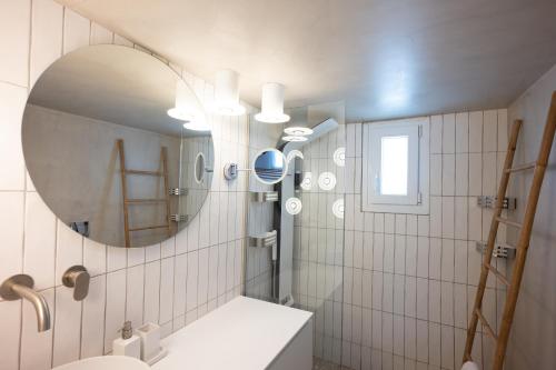 a bathroom with a sink and a mirror at Blue, White and Grey Suites in Ornos