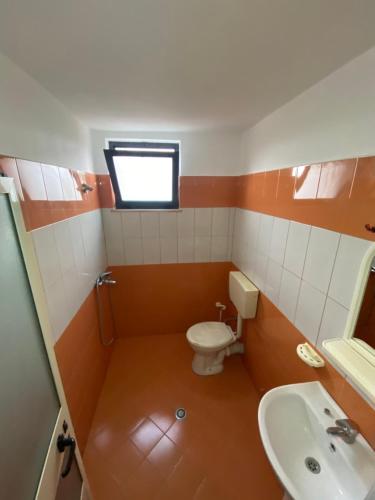 a small bathroom with a toilet and a sink at Villa Osmani in Durrës