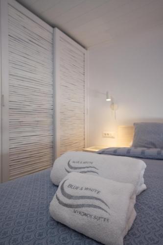 a bedroom with two beds with white towels at Blue, White and Grey Suites in Ornos