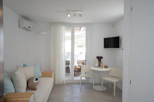 a living room with a couch and a table at Blue, White and Grey Suites in Ornos