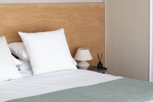a bed with a white pillow and a table with a lamp at Apartamentos Centro in Albacete