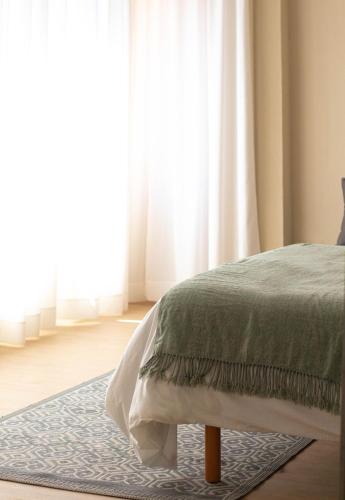 a bedroom with a bed and a large window at Apartamentos Centro in Albacete