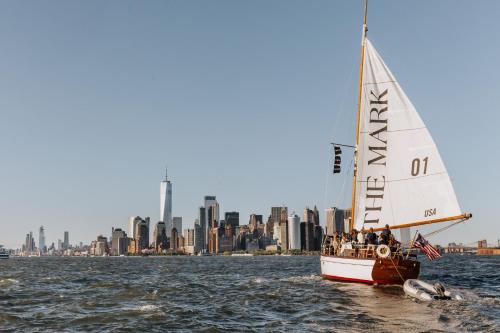 un voilier dans l'eau avec une ville en arrière-plan dans l'établissement The Mark New York, à New York