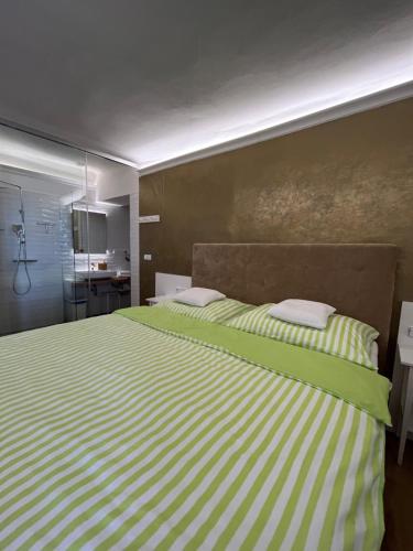 a bedroom with a bed with green and white stripes at Palác Daun - Studio Apartments in Znojmo