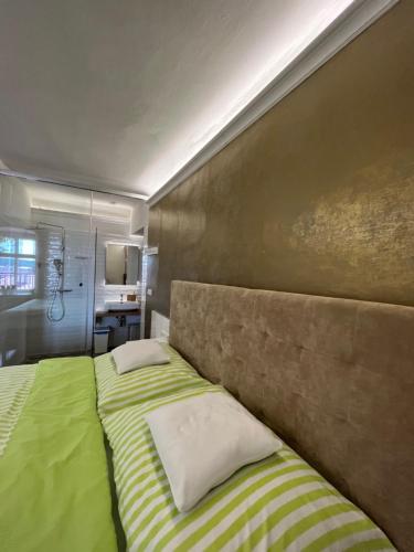 a bedroom with a bed with a green blanket at Palác Daun - Studio Apartments in Znojmo