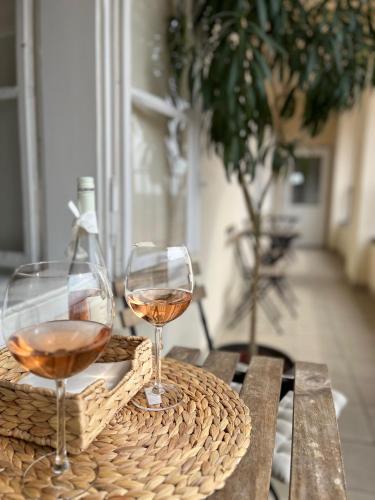 two glasses of wine sitting on a wooden table at Palác Daun - Studio Apartments in Znojmo