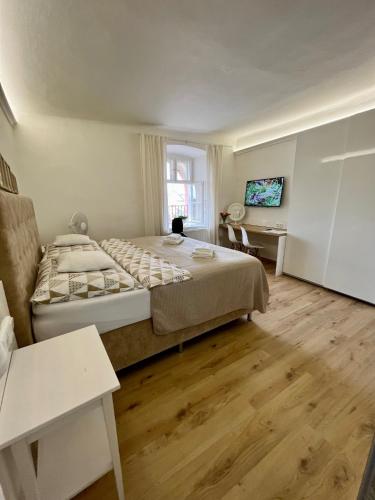 a bedroom with a large bed and a desk at Palác Daun - Studio Apartments in Znojmo