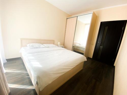 a bedroom with a large white bed and a mirror at Lux appartment, Comfort town, Kiev in Kyiv