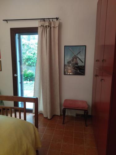 a bedroom with a bed and a window and a chair at La Casa di Cesarina in Celle sul Rigo