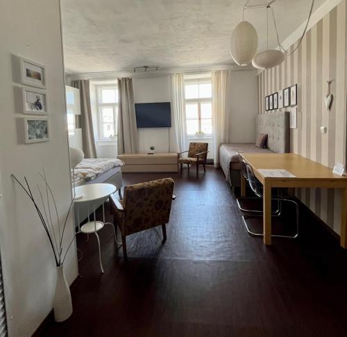 a hotel room with a bed and a table and a room at Palác Daun - Studio Apartments in Znojmo