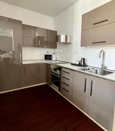 an empty kitchen with a sink and a microwave at Palác Daun - Studio Apartments in Znojmo
