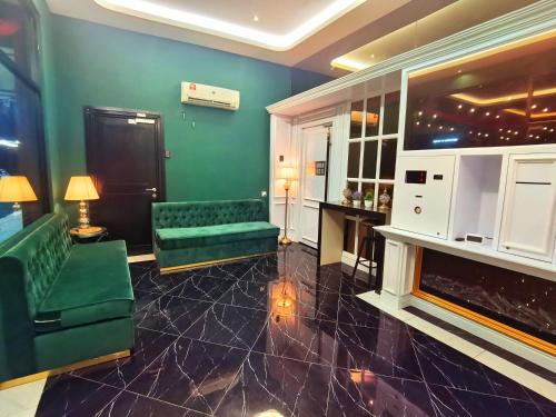 a living room with green couches and a fireplace at 1 Day Car Hotel - BG Perdana in Batu Gajah