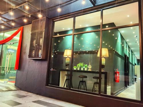 a window of a store with two stools in it at 1 Day Car Hotel - BG Perdana in Batu Gajah