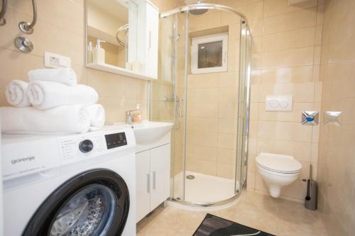 a bathroom with a washing machine and a toilet at Split Inn Apartments in Split