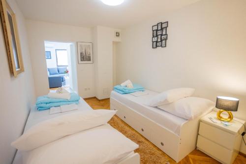 a room with two beds and a table with a lamp at Split Inn Apartments in Split