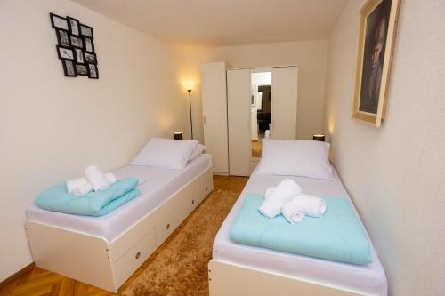 two beds in a room with blue and white at Split Inn Apartments in Split