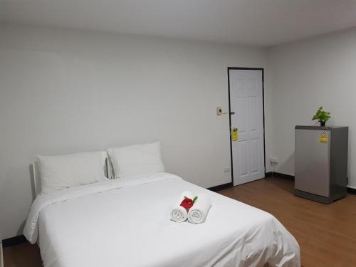 sypialnia z białym łóżkiem z dwoma butami w obiekcie NK Guesthouse 1 w mieście Klong Toi