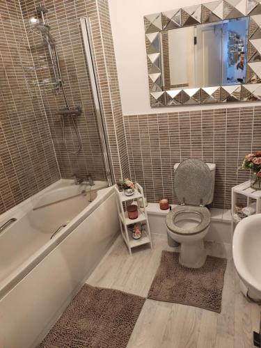 a bathroom with a tub and a toilet and a sink at Rothwell in Swansea
